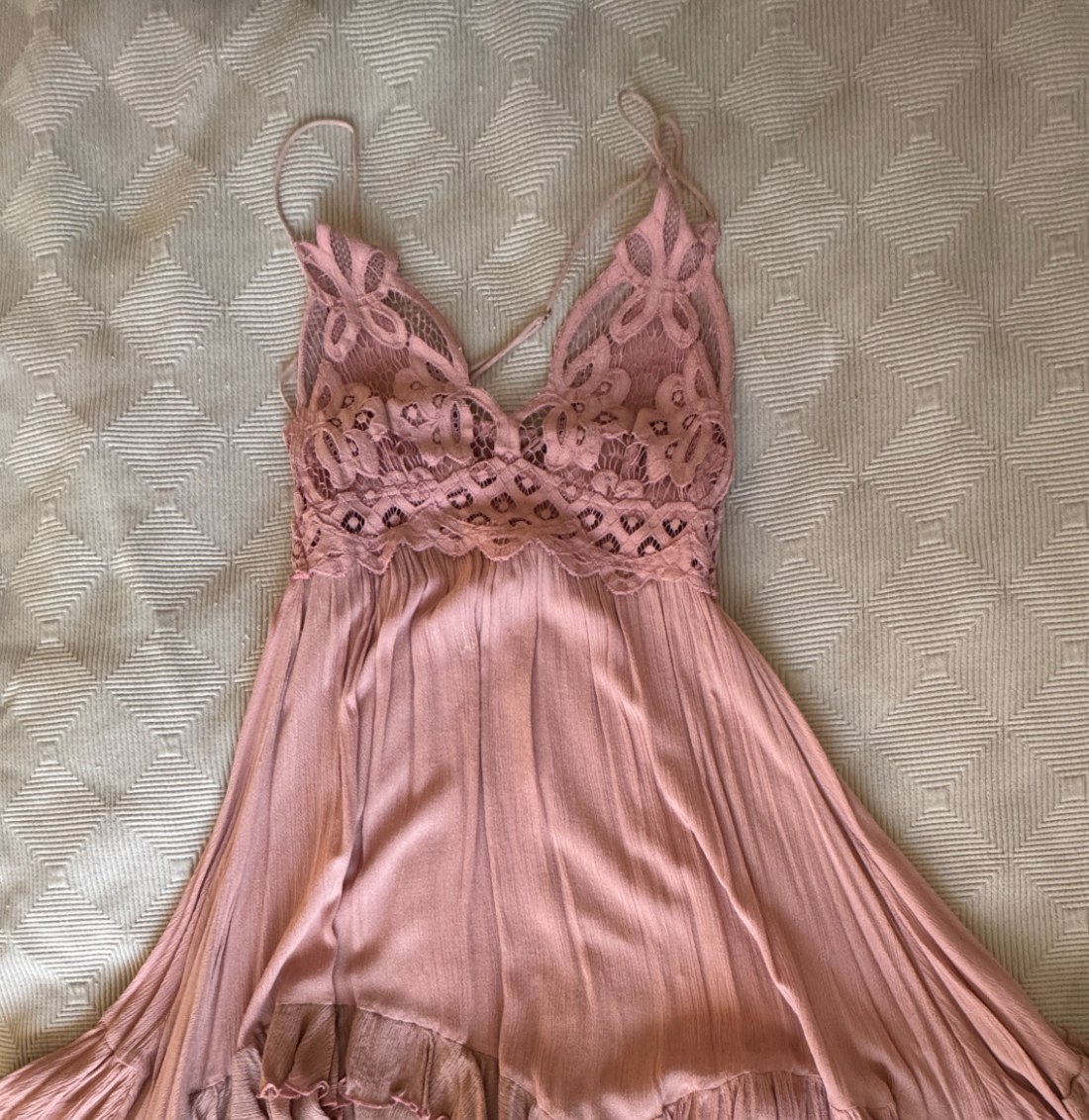 A blush lace slip dress photographed at home