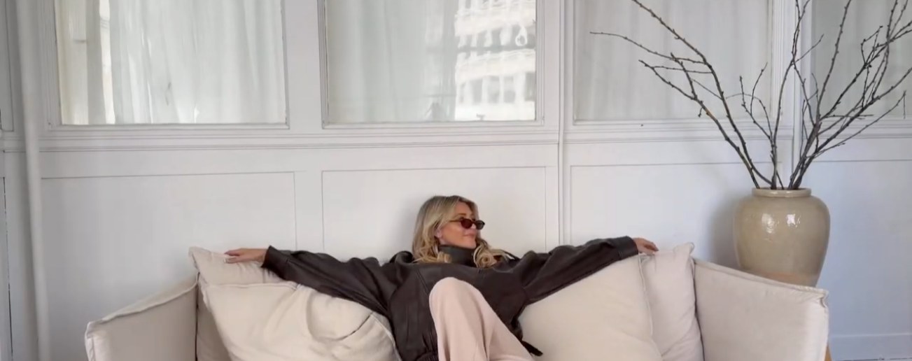 A member relaxing at home on a cream sofa